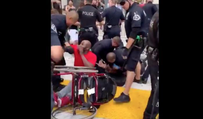 A Los Angeles la polizia ha aggredito un manifestante disabile e ha distrutto la sua sedia a rotelle
